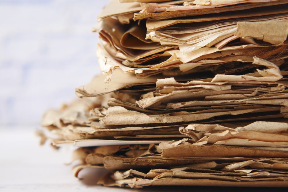 Stack of paper documents representing outsourced blog and social content for a B2B SaaS company